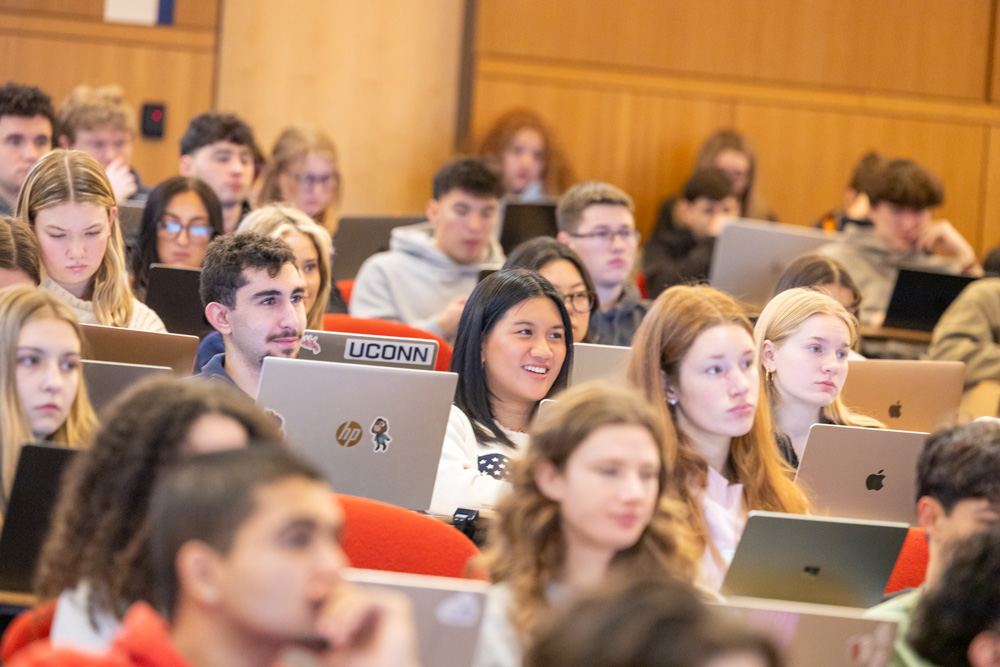 Students in a UConn lecture hall working on laptops during class.