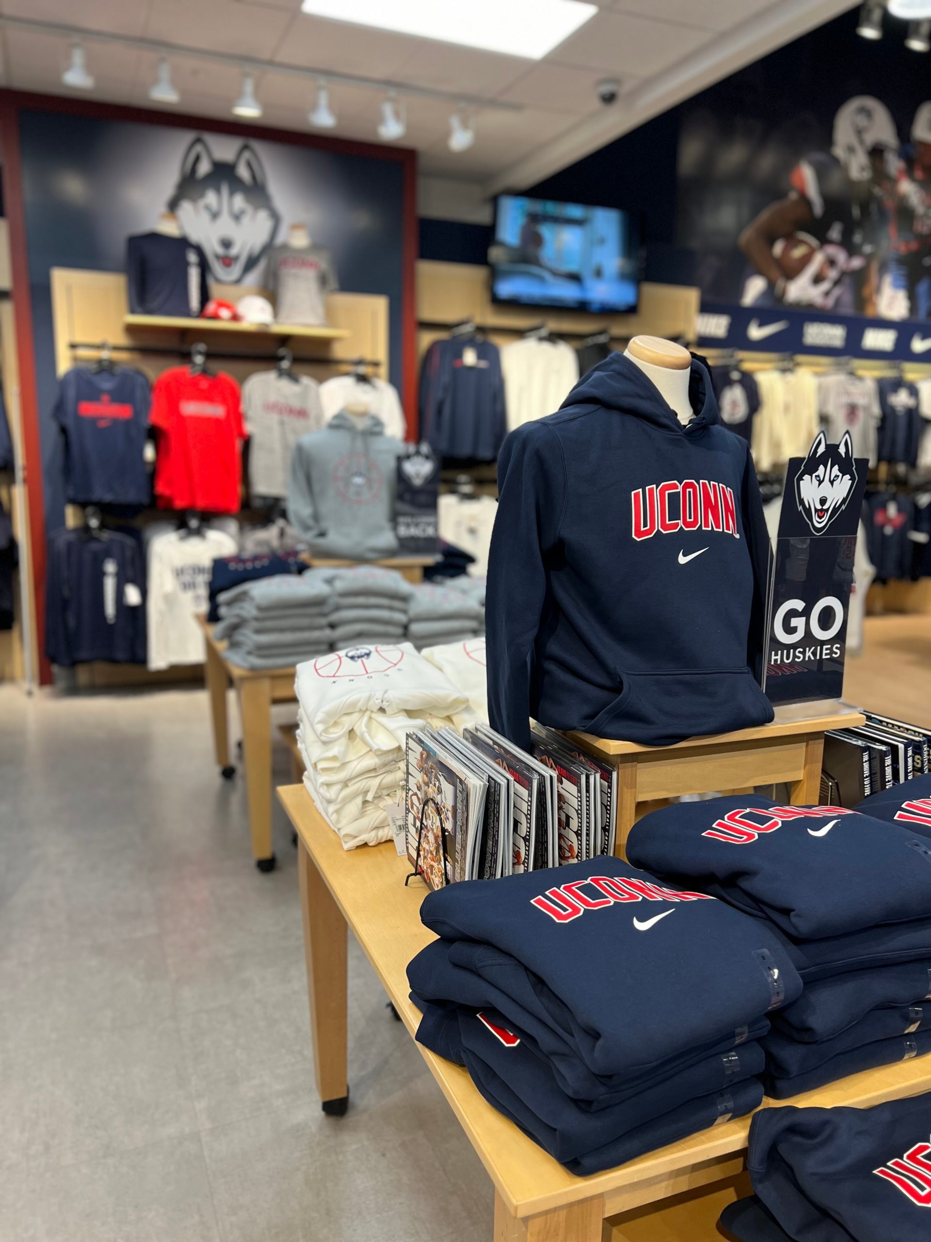 Clothing displays inside a fan store displaying UConn apparel